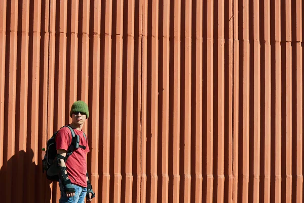 Mann Ausrüstung Mit Rucksack Steht Roter Wand Gebäude Hintergrund — Stockfoto