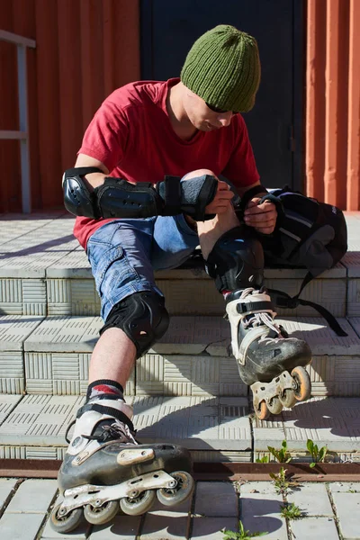 merdivenlerde oturan ve diz, ilk tıbbi yardım kavramı yaraya silerek paten erkekte 