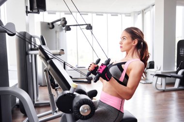 Sırt vasıl jimnastik salonu ip makinede egzersiz yaparak genç fitness eğitmeni 