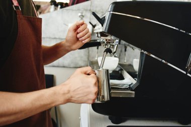 barista kahve makinesi kahve için süt hazırlarken kullanarak