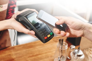 Terminal tutan kasiyer ve müşteri coffee shop telefonla ödeme temassız