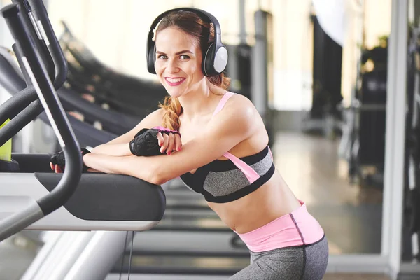 Mujer Atlética Auriculares Mirando Cámara Mientras Apoya Cinta Correr Gimnasio — Foto de Stock