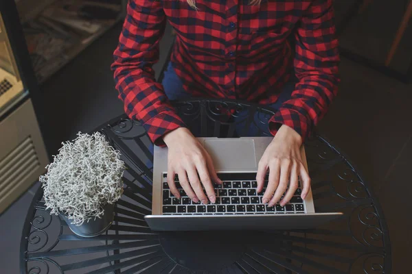 Kobieta Czerwonej Koszuli Wpisując Klawiaturze Laptopa Siedząc Przy Stoliku Kawiarni — Zdjęcie stockowe