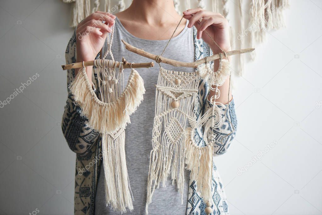 woman holding macrame decorations, close-up, female hobby concept 