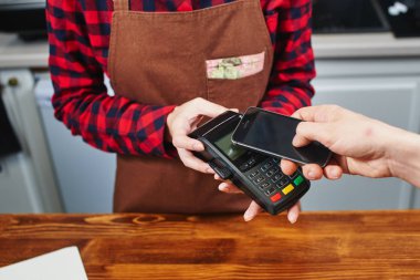 Erkek müşteri kahve barista kadın ile smartphone için ödeme