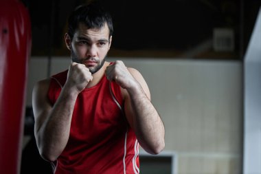 Boksta agresif Fighter portre arka plan üzerinde kum torbası ile spor salonunda 