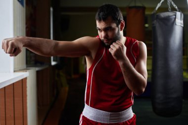 brunet boksör uygulamak için kanca oluşturur ve spor salonunda darbeler 