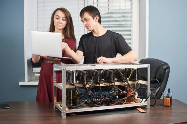laptop ekran kartı çiftlik cryptocurrency incelemesi için kurma adam tutan genç kadın