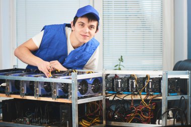 cryptocurrency ofiste çıkarılması için çiftlikte eğilerek üniformalı genç adam 