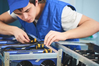 Genç adam cryptocurrency çıkarım için çiftlik kurma konsantre