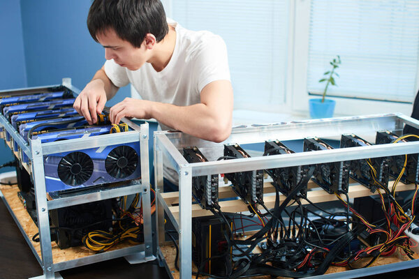 worker checking farm for extraction of cryptocurrency in laboratory