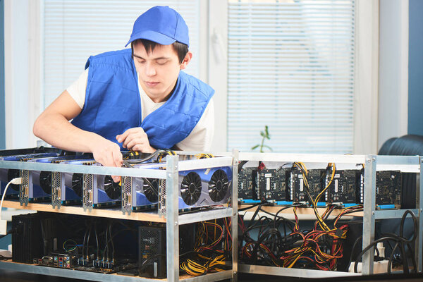 concentrated young man setting up farm for extraction of cryptocurrency
