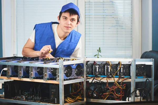 cryptocurrency ofiste çıkarılması için çiftlikte eğilerek üniformalı genç adam 