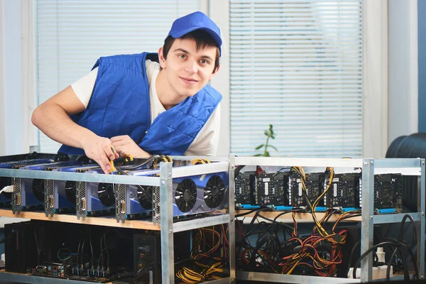 cryptocurrency ofiste çıkarılması için çiftlikte eğilerek üniformalı genç adam 