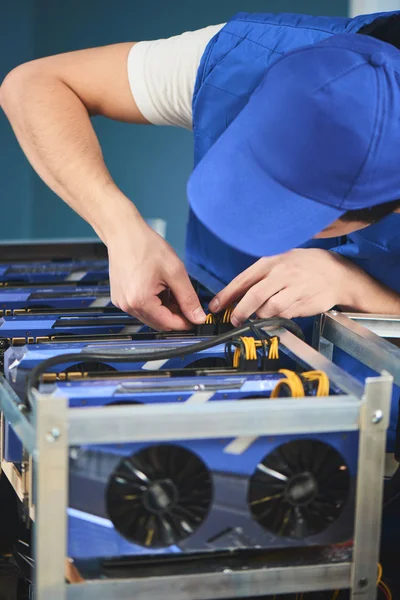 Genç adam cryptocurrency çıkarım için çiftlik kurma konsantre