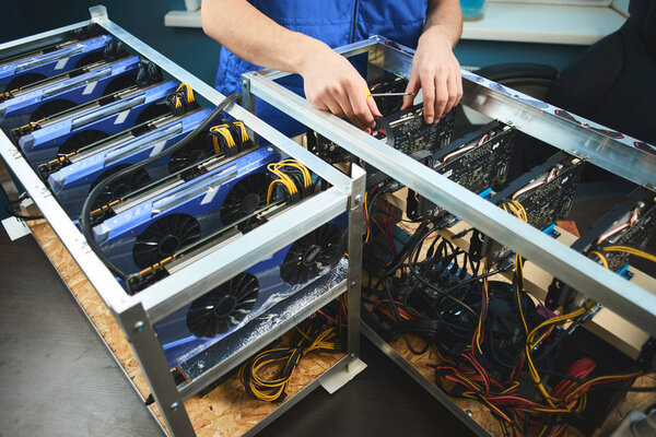 male hands setting up farm for extraction of cryptocurrency