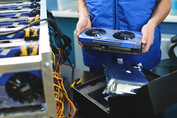 Erkek Çiftliği bitcoin madencilik ayarlamak için ekran kartı tutan eller