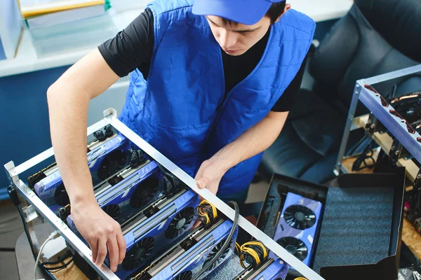 Genç adam bitcoin incelemesi için ekran kartları çiftlikte kurma