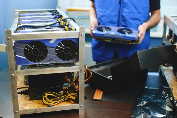 Erkek Çiftliği bitcoin madencilik ayarlamak için ekran kartı tutan eller