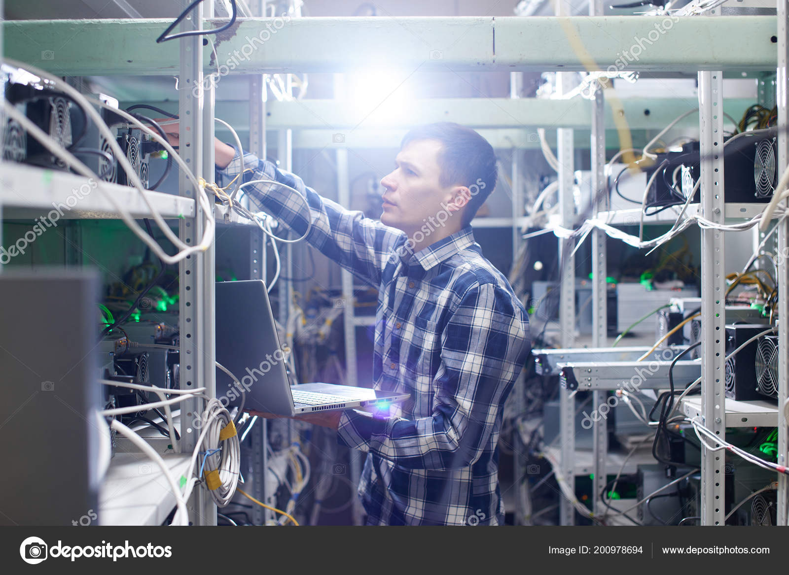 Concentrated Worker Holding Laptop While Setting Farm Mining Cryptocurrency  — Stock Photo © amixstudio #200978694