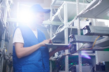 dizüstü ekipman için araştırma cryptocurrency çiftliğinde ile ayakta işçi 