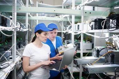 Genç adam ve kadın ile çiftlik çıkarım kripto para birimleri, bitcoin incelemesi kavramı için dizüstü bilgisayar kurma