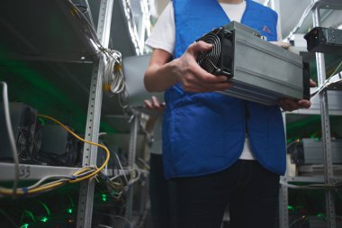 Bitcoin madencilik ekipmanları cryptocurrency çiftlikte elinde tutan erkek işçi