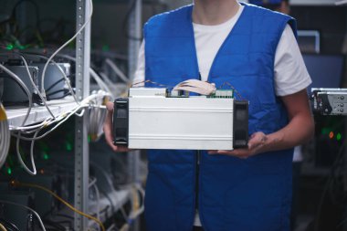 bitcoin madencilik ekipmanları depolama cryptocurrency çiftliğinde elinde tutan üniformalı erkeklere 