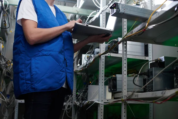 dizüstü ekipman için araştırma cryptocurrency çiftliğinde ile ayakta işçi 