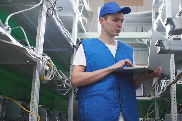 dizüstü ekipman için araştırma cryptocurrency çiftliğinde ile ayakta işçi 