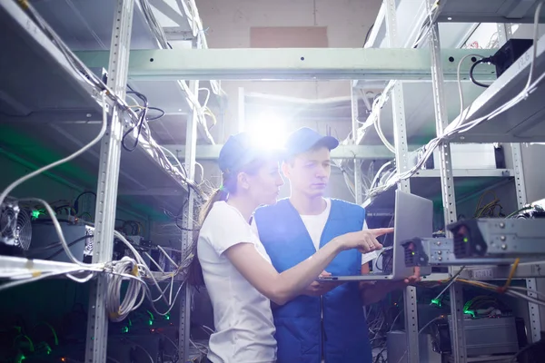 Genç adam ve kadın ile çiftlik çıkarım kripto para birimleri, bitcoin incelemesi kavramı için dizüstü bilgisayar kurma