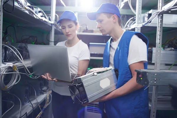 Genç adam ve kadın ile çiftlik çıkarım kripto para birimleri, bitcoin incelemesi kavramı için dizüstü bilgisayar kurma