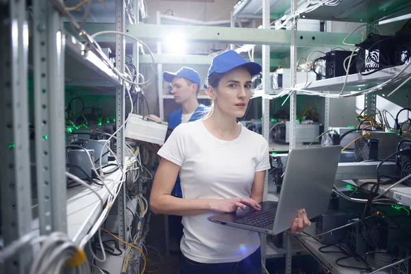 kadın bilgisayar mühendisi çalışma üstünde laptop meslektaşım çiftlik çıkarım kripto para birimleri, bitcoin incelemesi kavramı için kontrol ederken