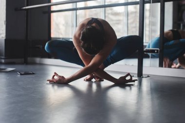 Kadın pratik yoga teşkil spor salonunda 