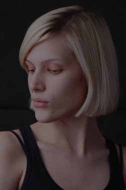 şık kadın sarışın model siyah singlet koyu arka plan üzerinde poz içinde 