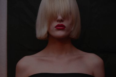 koyu arka plan üzerinde kırmızı dudaklar çekici sarışın kadınla 