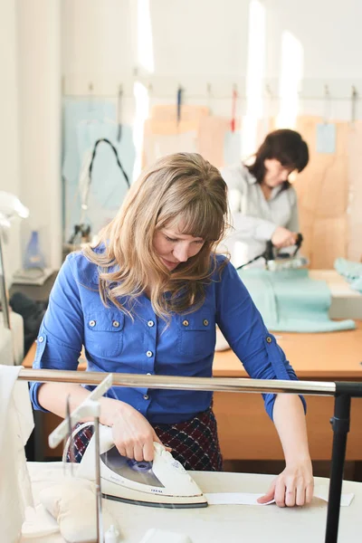 iki seamstresses atelier zincire ile elbise Ütü