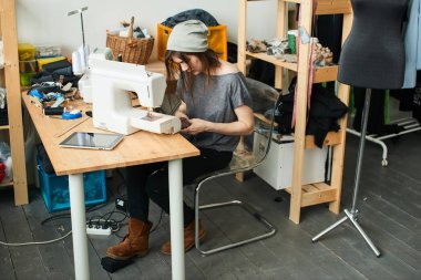 atelier dikiş makinesi ile şapka dikiş bez içinde çekici esmer terzi