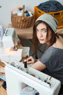 atelier dikiş makinesi ile şapka dikiş bez içinde çekici esmer terzi