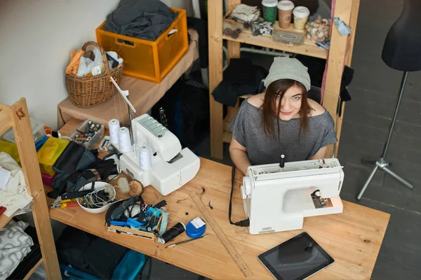 atelier dikiş makinesi ile şapka dikiş bez içinde çekici esmer terzi