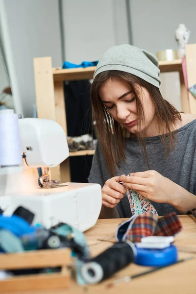 atelier dikiş makinesi ile şapka dikiş bez içinde çekici esmer terzi