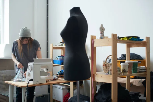 Tekstil Atölyesi giysilerle oluşturulması üzerinde çalışırken masaya koyarak terzi konsantre