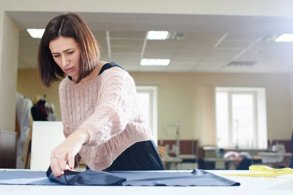 テーブル 測定テープ アトリエ コンセプトの服の作成に繊維を入れて仕立て屋を集中してください — ストック写真