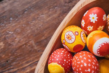 ahşap kase boyalı renkli Paskalya yığını ile kahverengi zemin üzerine yumurta 