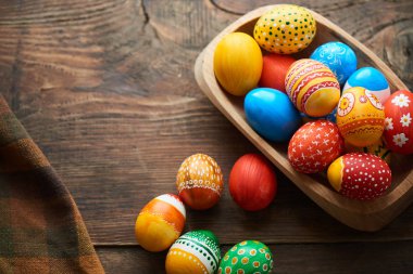ahşap masa, Paskalya tatil kavramı ıslak zeminde çeşitli desenler ile renkli yumurta boyalı  