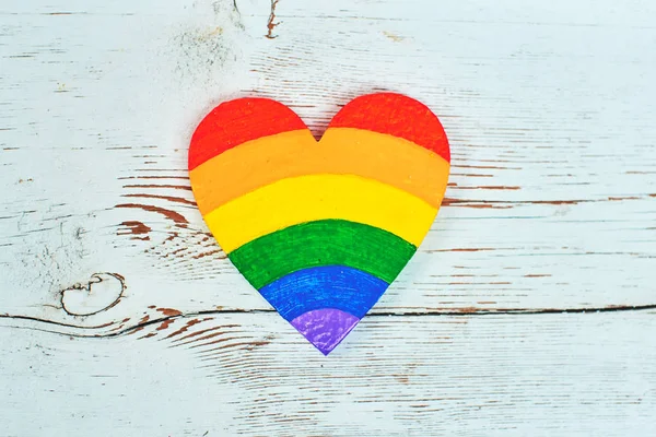 Heart painted in rainbow colors on wooden background, LGBT concept