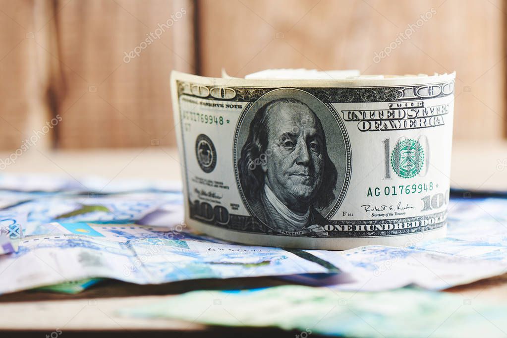 Dollars and tenge on a wooden background. Kazakhstan currency. Business and money