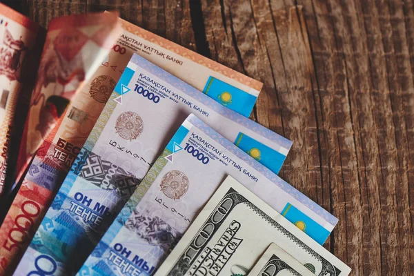 Haufen Amerikanischer Dollars Und Kasachstan Tenge Auf Hölzernem Hintergrund Nahaufnahme — Stockfoto