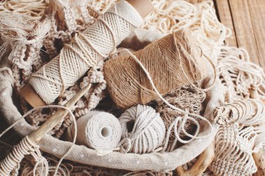 Needlework, macrame, knitting. Yarn and thread of natural colors in a wicker basket. Women's hobby. clipart