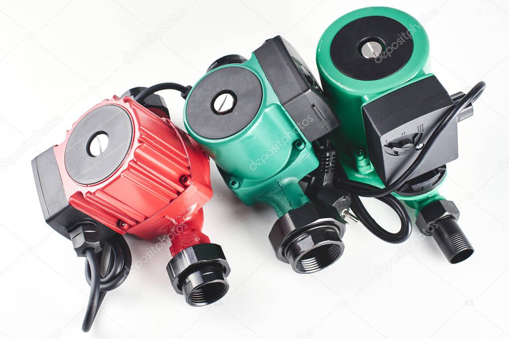 Red and green circulation pumps for heating on a white background.